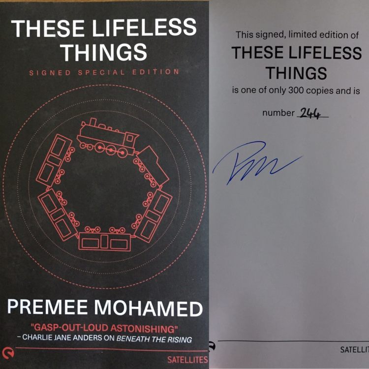 The cover for Premee Mohamed's "These Lifeless Things." The cover is black with white text, and a red train running in a circle in the center. Attached to the cover photo is a second photo of the interior front page, which shows Mohamed's Signature, and that the book is a limited edition copy, number 244 of 300.